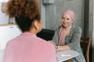 Two women in conversation, one wearing a headscarf.